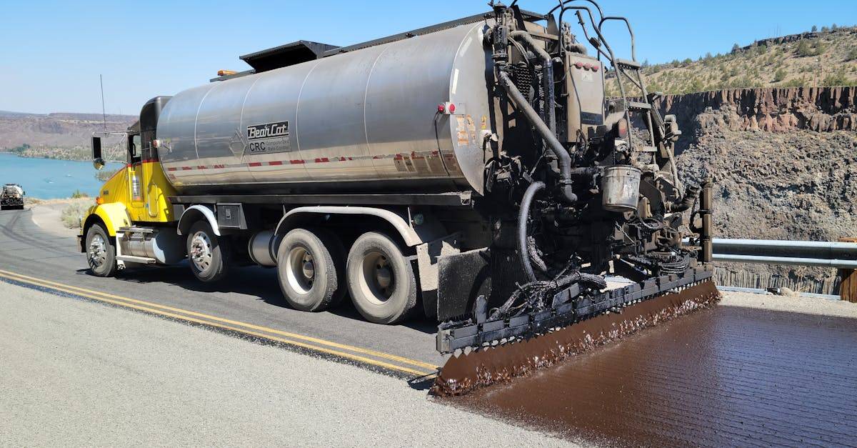 Chip seal truck applying asphalt on a highway near lake in Madras, Oregon.